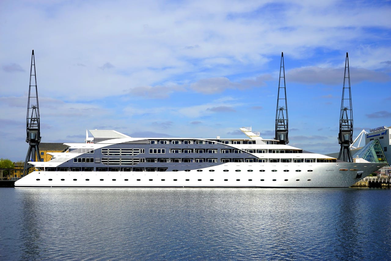 Stunning view of a luxury cruise ship docked at a modern harbor under a blue sky.